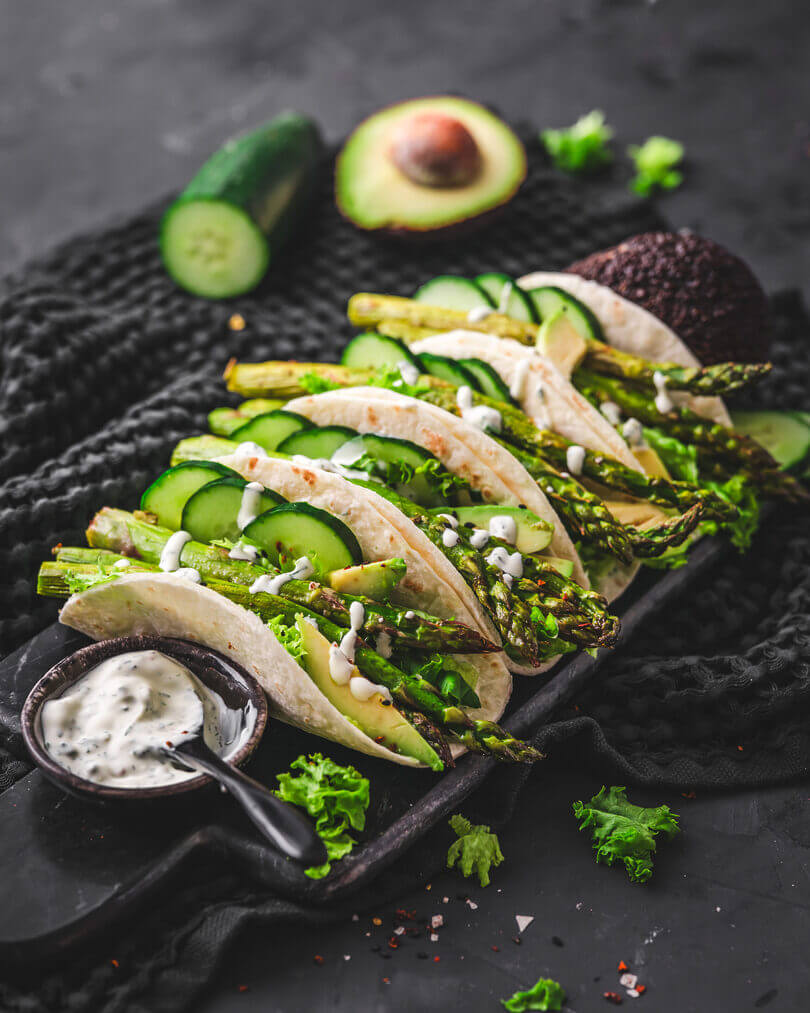 Wraps gefüllt mit grünem Spargel, Avocado, Gurke und Salat – eine kreative Servieridee für gebackenen Spargel.