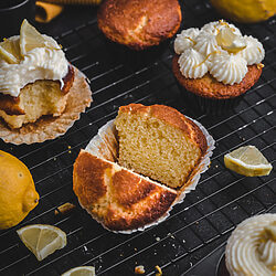 Anschnitt eines fluffigen Zitronenmuffins mit Joghurt auf schwarzem Gitter