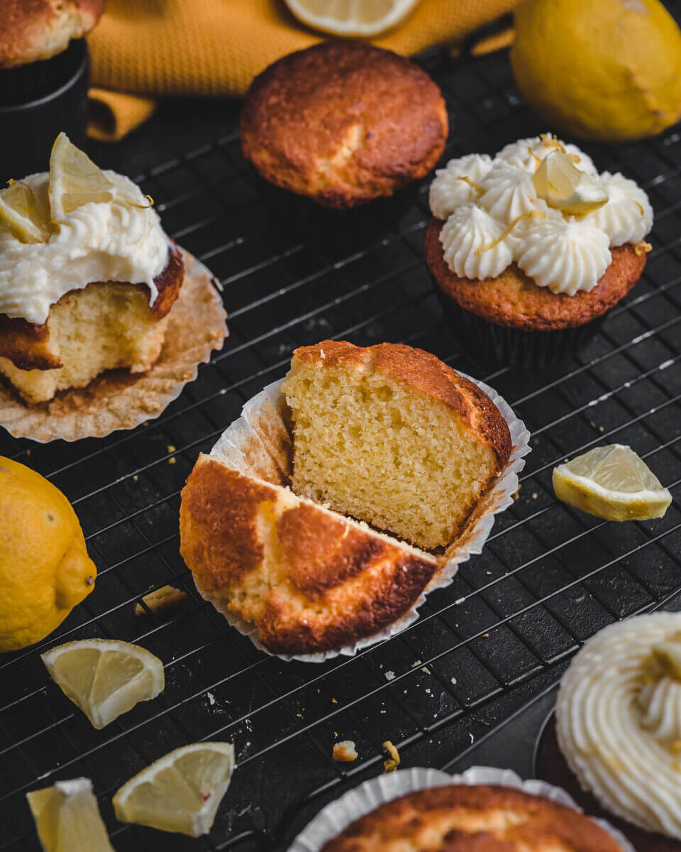 Anschnitt eines fluffigen Zitronenmuffins mit Joghurt auf schwarzem Gitter